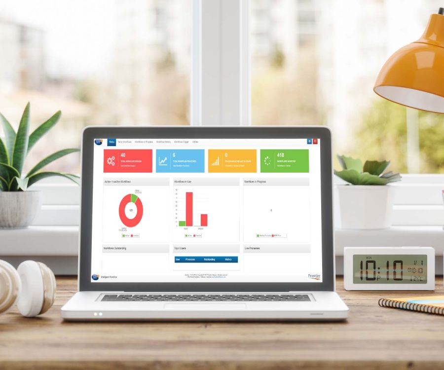 Image of laptop computer on bright and modern desk. The screen shows a report from the Intelligent Workflow module from Frontier Software