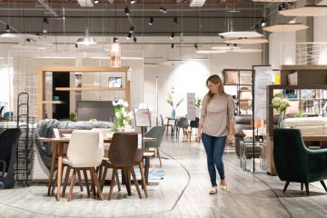 Image depicting woman strolling through contemporary furniture showroom