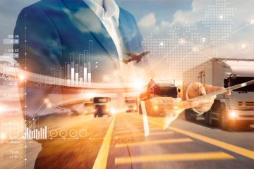 A futuristic image of a businessman managing logistics operations with a tablet, overseeing a highway filled with trucks and a digital map.