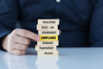 A stack of wooden blocks showing business and legal terms with the word, "Compliance", highlighted in yellow.