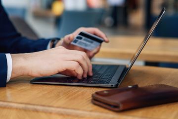 A person makes a secure online payment using a credit card and smartphone.