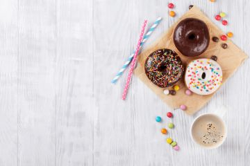 Image of donuts and hot beverage on a serving board.